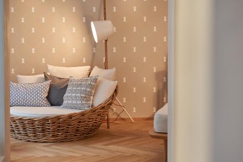 a room with a rattan chair with pillows at Hotel Rössle in Au im Bregenzerwald