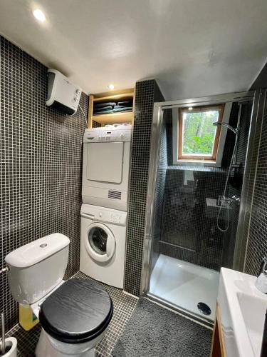a small bathroom with a toilet and a shower at Cozy warm chalet in wooden nature near Maastricht-Gothamette House in Lanaken