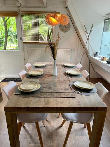 a wooden table with chairs and a dining room at Cozy warm chalet in wooden nature near Maastricht-Gothamette House in Lanaken