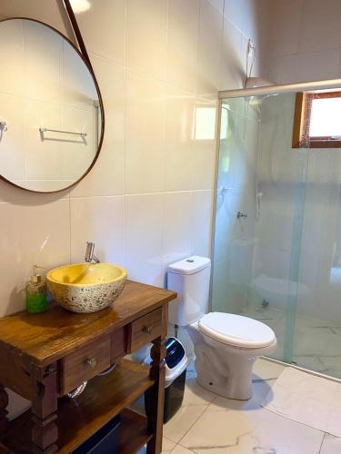 a bathroom with a sink and a toilet and a mirror at Villetta Gramado Roma in Gramado