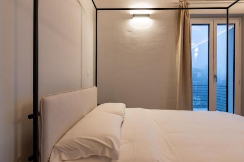 a bedroom with a white bed and a window at Guest house Neive in Neive