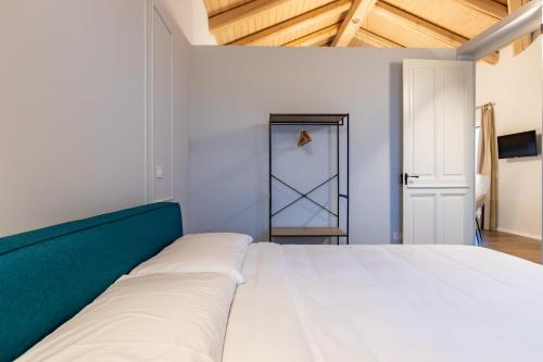 a bedroom with a white bed with a green headboard at Guest house Neive in Neive