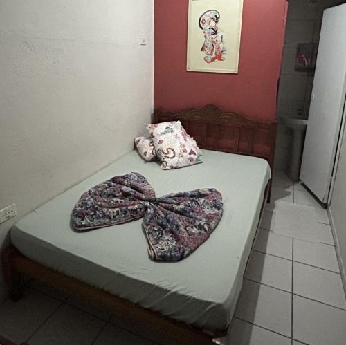 a room with a bed with a bow tie on it at Pousada Orquidário in Santos