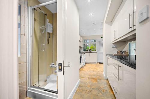 a kitchen with a door open to a hallway with a counter at Harborne House, Perfect for Contractors & Families, sleeps 8 in Birmingham