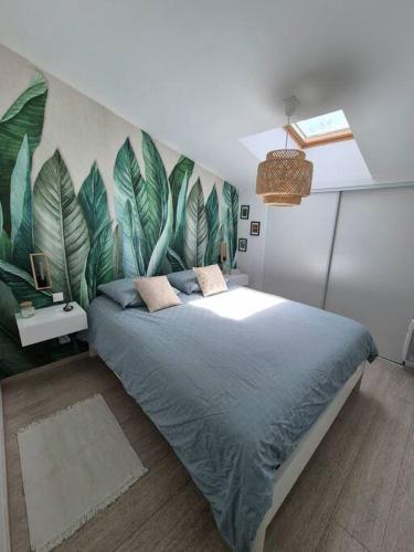 - une chambre avec un grand lit orné d'une fresque murale représentant des feuilles dans l'établissement Appartement T3 campagne, à Forcalqueiret