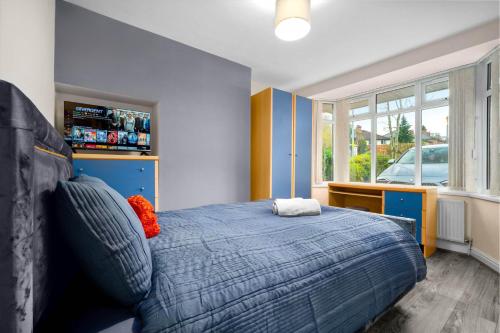 a bedroom with a blue bed and a window at Harborne House, Perfect for Contractors & Families, sleeps 8 in Birmingham