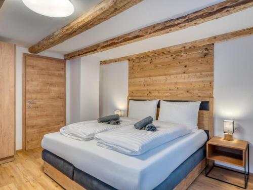 a bedroom with a large bed with a wooden wall at Chalet Bergglück in Sellrain