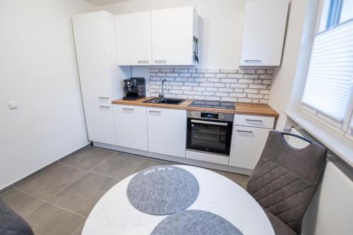 a kitchen with white cabinets and a table and chairs at Quiet House - 10 min away from Cologne in Bergisch Gladbach