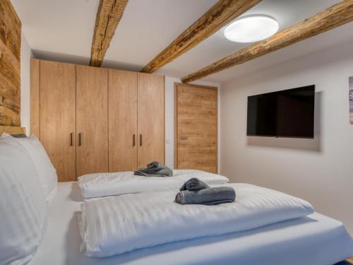 a bedroom with two beds and a flat screen tv at Chalet Bergglück in Sellrain