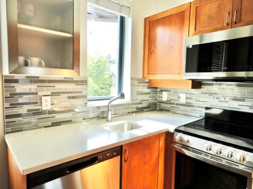 a kitchen with a sink and a microwave at Alpenglow Lodge Two Bedroom Apartment by MVA in Whistler