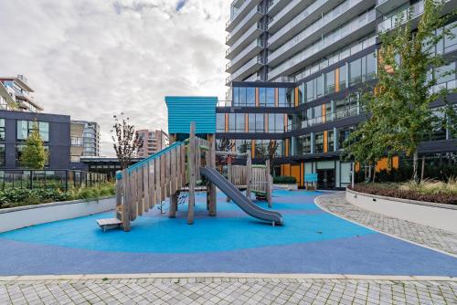 a playground in front of a building with a slide at Brand new Stylists Richmond central 2B2BR in Richmond