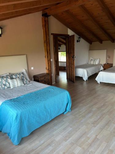 a bedroom with two beds and a wooden floor at El LABRAO DE ALARDOS in El Raso