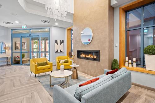 a lobby with two couches and a fireplace at Alpenglow Lodge Snooze Studio with Den by MVA in Whistler