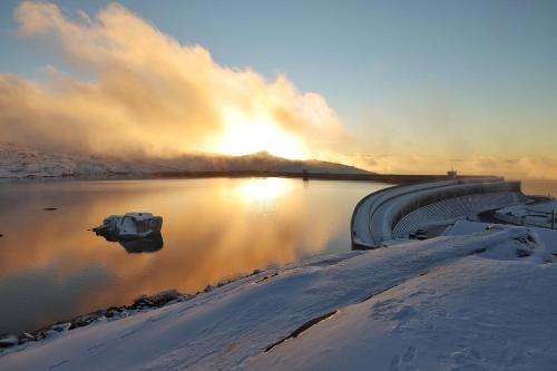 a body of water with the sun in the background at Mountain Lodge T3 Duplex Abrigo do Lobo in Covilhã