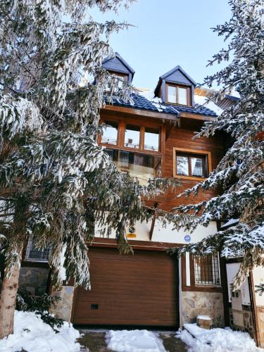 a house with a garage in the snow at CASA ABETOS Elite in Sierra Nevada