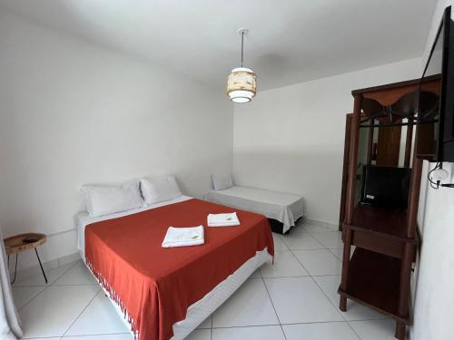 a room with a bed with a red blanket at D'Ajuda Inn in Arraial d'Ajuda