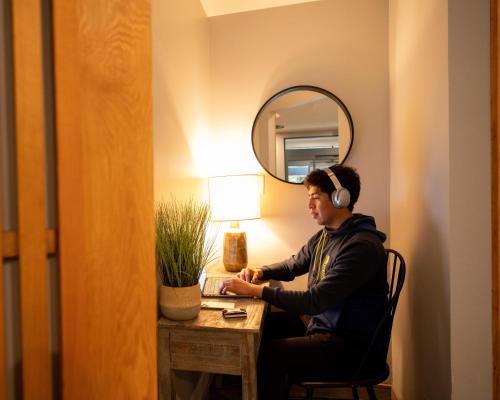 a man wearing headphones sitting at a desk in a room at Alpenglow Lodge Fika One Bedroom by MVA in Whistler