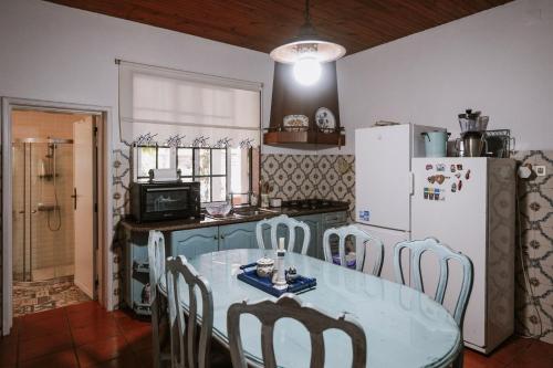 a kitchen with a table with chairs and a refrigerator at Casa Rural Oliveira do Bairro in Oliveira do Bairro