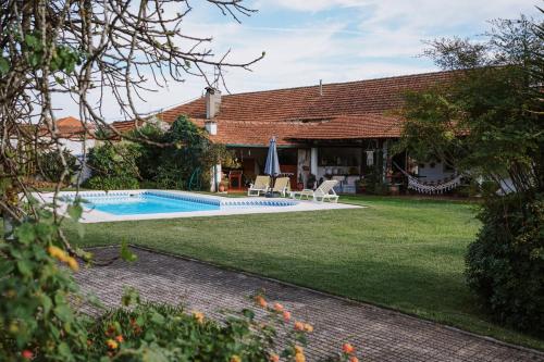 a house with a swimming pool in a yard at Casa Rural Oliveira do Bairro in Oliveira do Bairro