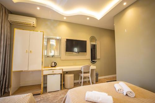 a bedroom with a desk and a tv on the wall at Hotel Flash in Istanbul