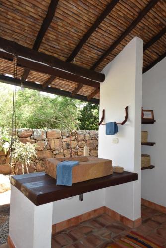 a bathroom with a sink with a stone wall at B&B Buenavista Barichara in Barichara
