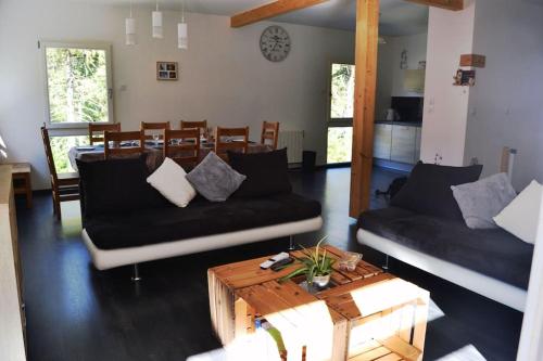 ein Wohnzimmer mit zwei Sofas und einem Couchtisch in der Unterkunft Chalet Au Cottage des Lynx in Xonrupt-Longemer