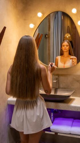 a woman standing in front of a bathroom mirror at Diwatu Villas in El Nido