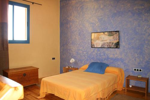 um quarto com uma cama e uma parede azul em El Vuelo de la Libélula em Barbate