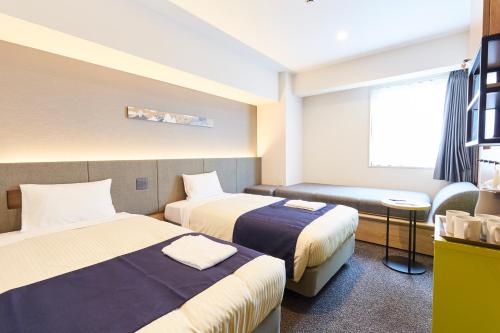 a hotel room with two beds and a window at hotel MONday Akihabara Asakusabashi in Tokyo