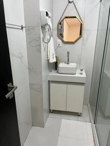 a white bathroom with a sink and a shower at Move 517 in João Pessoa