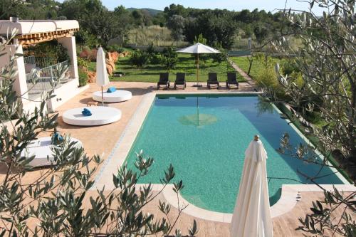 a swimming pool with two umbrellas and two chairs at Villa Luna in Sant Joan de Labritja