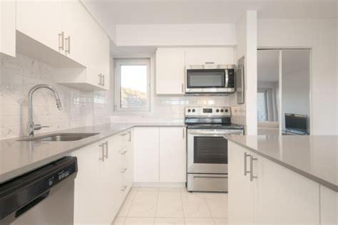a white kitchen with a stove and a microwave at appartement 1 chambre et salon spacieux in Montréal
