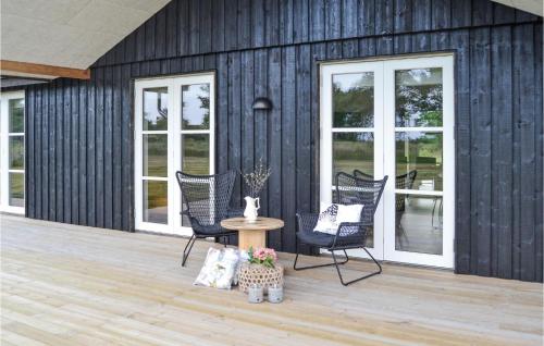 a patio with chairs and a table and windows at Holiday Home Sæby 59 in Nordost