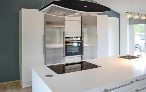 a kitchen with a white counter and a refrigerator at Holiday Home Sæby 59 in Nordost