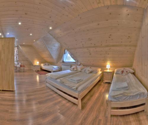 Apartamenty u Piekorza في شافلاري: سريرين في غرفة ذات سقف خشبي
