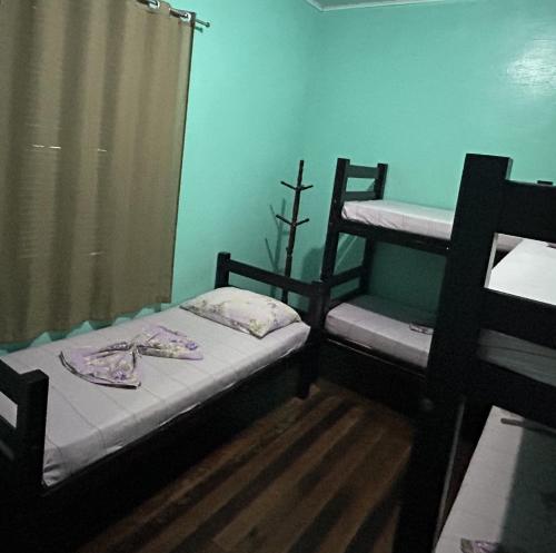 a small room with two bunk beds and a window at Pousada Orquidário in Santos