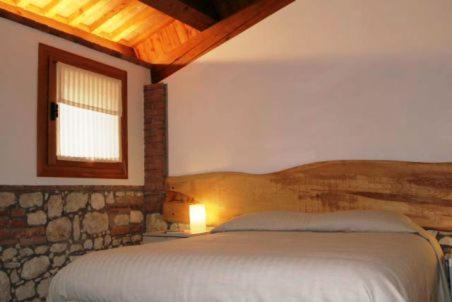 1 dormitorio con 1 cama en una habitación con ventana en Tenuta Maraveja, en Brendola