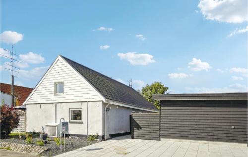 a white house with a garage and a building at 3 Bedroom Gorgeous Home In Asaa in Aså