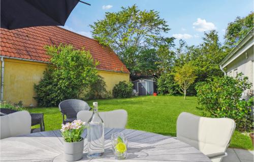 a table with a bottle of wine and flowers on it at 3 Bedroom Gorgeous Home In Asaa in Aså
