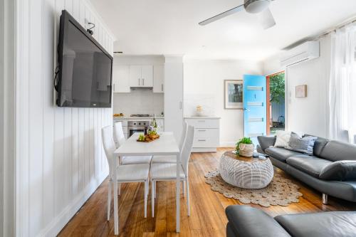 a living room with a table and a couch at Orton Blue- Beachside getaway for 4, Pets welcome, Aircon, Park and walk to everything! in Ocean Grove