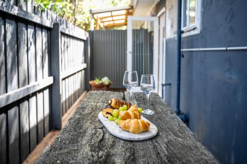 a plate of food on a table with wine glasses at Orton Blue- Beachside getaway for 4, Pets welcome, Aircon, Park and walk to everything! in Ocean Grove