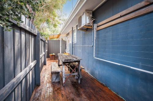 a blue building with a table next to a blue wall at Orton Blue- Beachside getaway for 4, Pets welcome, Aircon, Park and walk to everything! in Ocean Grove