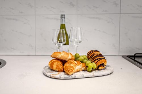 a plate of bread and grapes and wine glasses at Orton Blue- Beachside getaway for 4, Pets welcome, Aircon, Park and walk to everything! in Ocean Grove