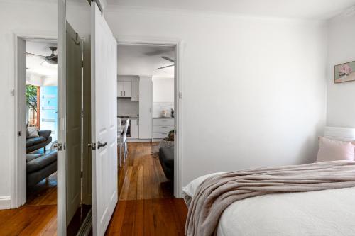 a bedroom with a bed and a living room at Orton Blue- Beachside getaway for 4, Pets welcome, Aircon, Park and walk to everything! in Ocean Grove