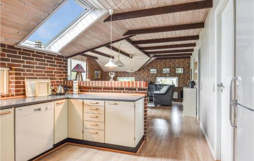 a kitchen with a brick wall and a skylight at Holiday Home P Snejkers Vej Ringkøbing I in Søndervig