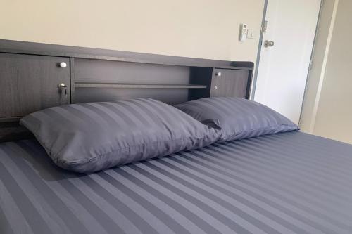 a bed with a pillow on it in a room at Na Nont Place in Bangkok