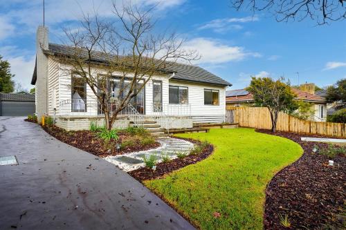 a house with a yard and a fence at 4 Bedroom Home in Heathmont Perfect for Families in Heathmont