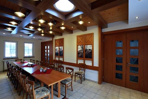 a dining room with a long table and chairs at Wellness Penzion Pod Rozhlednou in Kostelec nad Orlicí