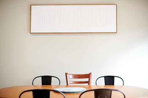 a dining room table with chairs and a picture on the wall at 4 Bedroom Home in Heathmont Perfect for Families in Heathmont