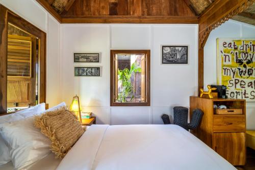 a bedroom with a large white bed and a window at Salty Siesta Stays in Selong Belanak
